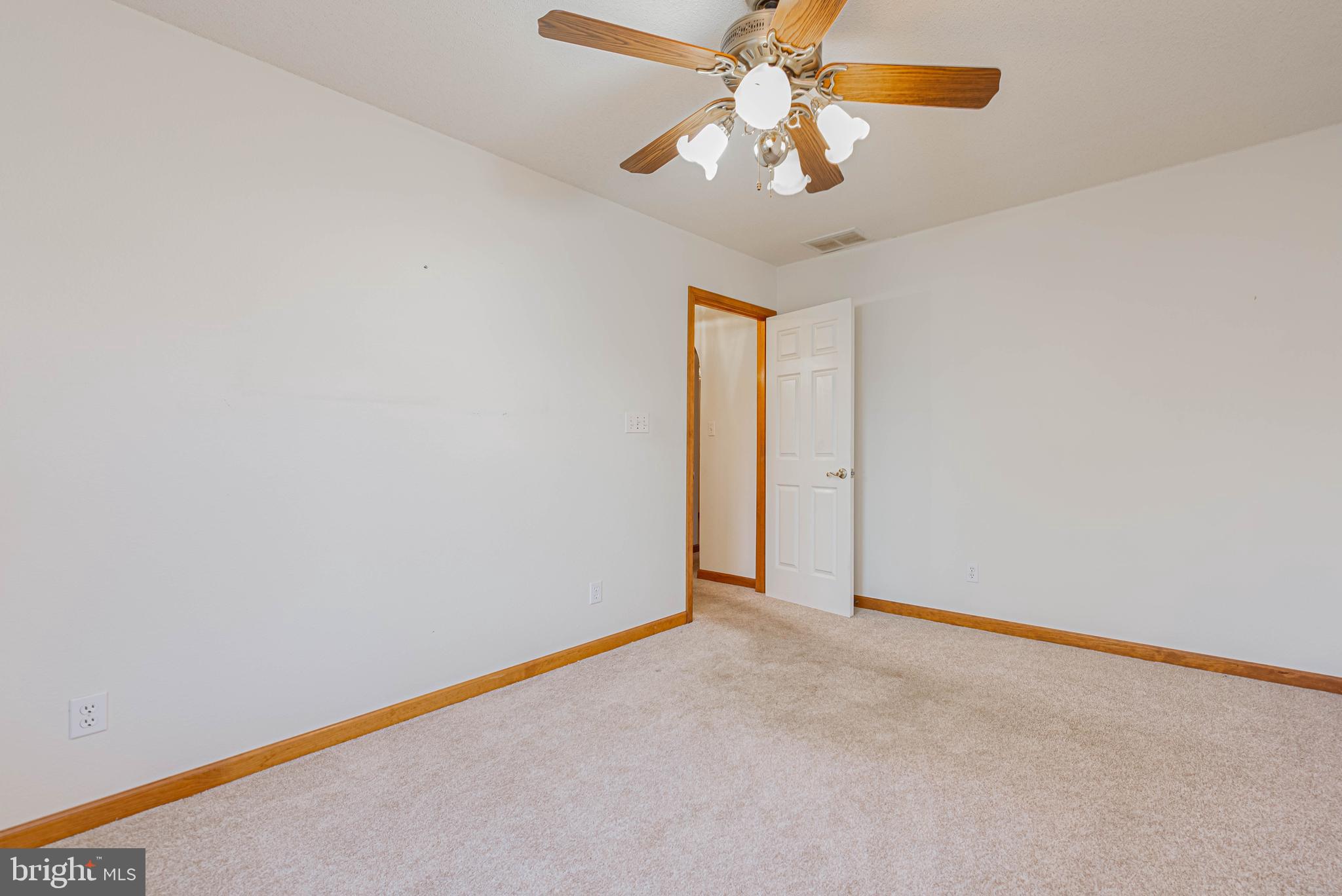 35772 Egret Road Selbyville, DE 19975 - Photo 31 of 38 an empty room with a chandelier fan and windows