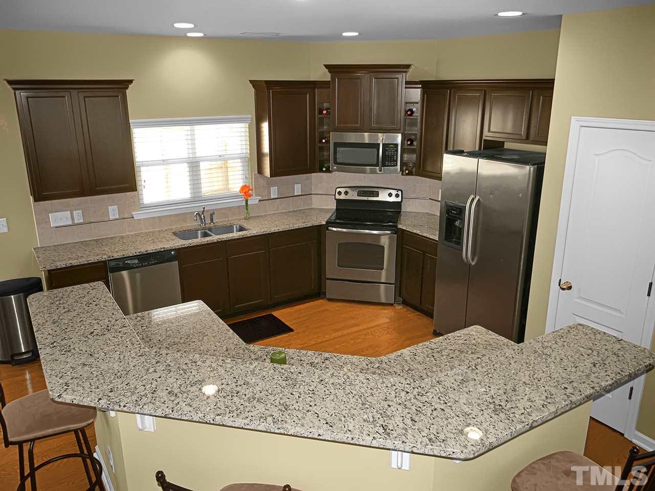 4418 Cardinal Grove Boulevard Raleigh, NC 27616 - Photo 4 of 23 Granite countertops, stainless steel appliances, custom cabinets with crown molding and built-in wine storage, tile backsplash, pantry