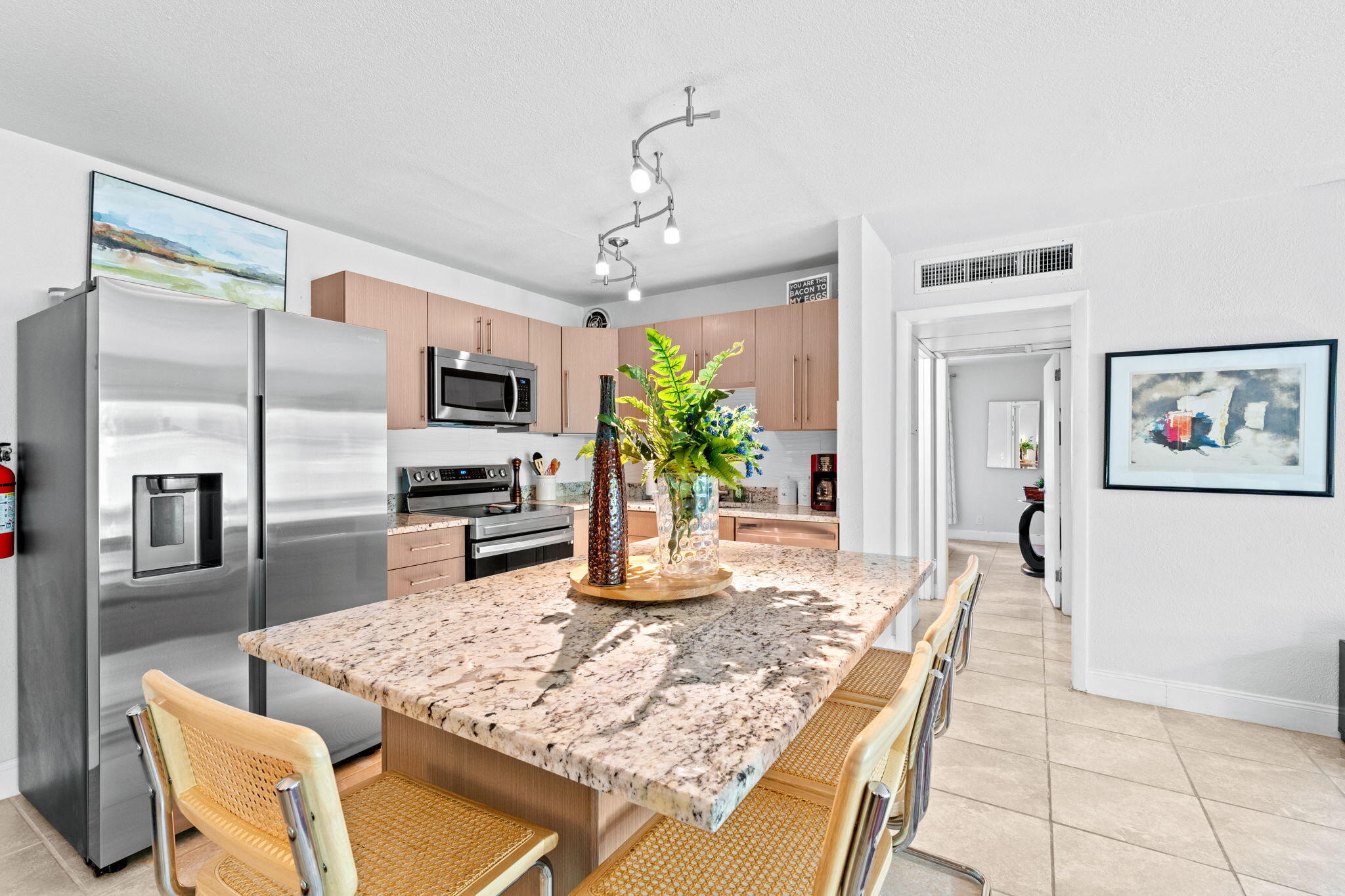 3725 South Olive Avenue, Unit A West Palm Beach, FL 33405 - Photo 13 of 35 a kitchen with stainless steel appliances granite countertop a refrigerator a oven a sink a dining table and chairs with wooden floor