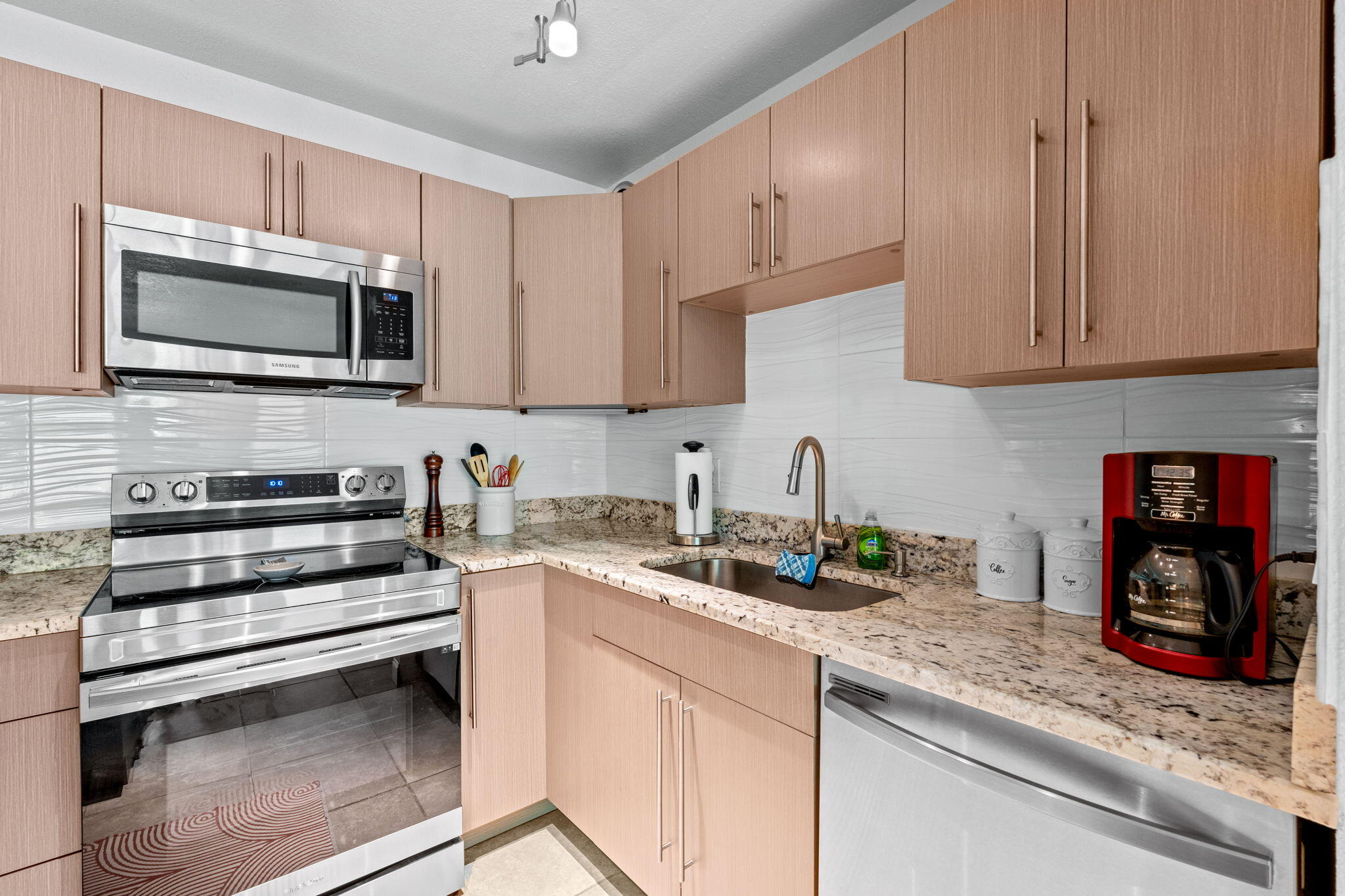 3725 South Olive Avenue, Unit A West Palm Beach, FL 33405 - Photo 17 of 35 a kitchen with stainless steel appliances granite countertop a stove microwave and cabinets
