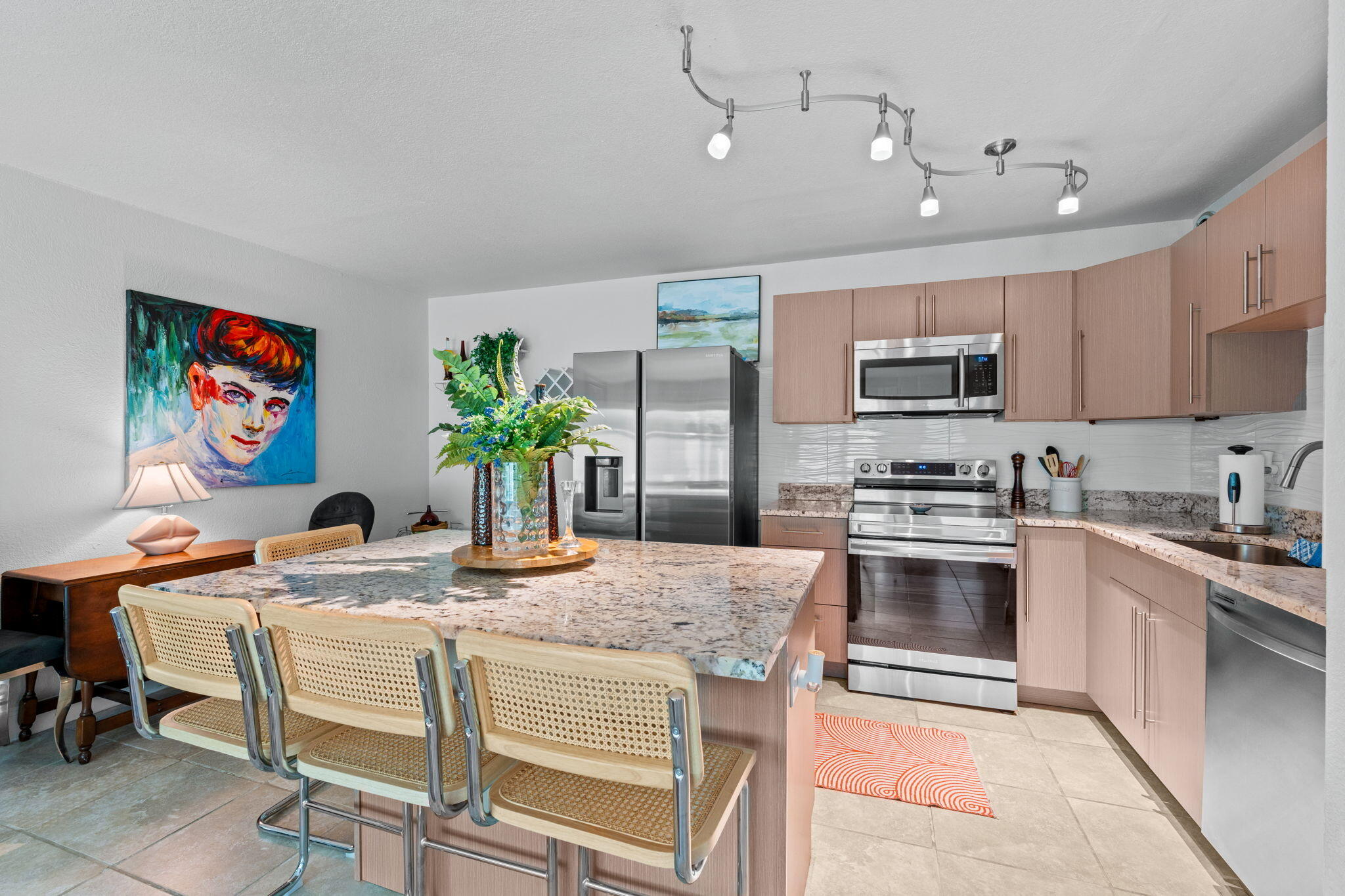 3725 South Olive Avenue, Unit A West Palm Beach, FL 33405 - Photo 18 of 35 a kitchen with stainless steel appliances granite countertop a stove top oven a sink a dining table and chairs