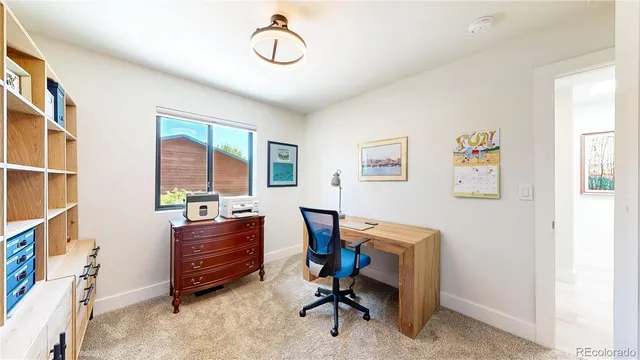 a view of workspace with lounge chair and windows