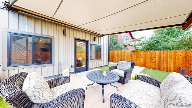 a backyard of a house with yard table and chairs