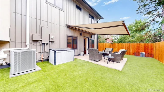 a view of a backyard with table and chairs potted plants with wooden fence