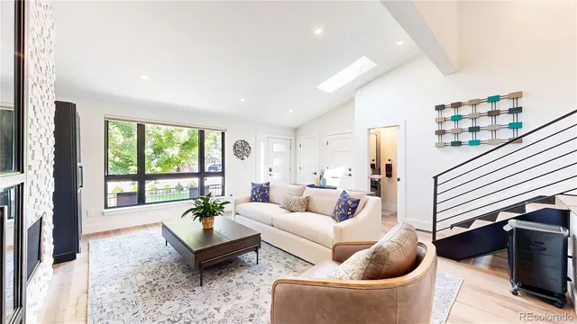 a living room with furniture a rug and a large window