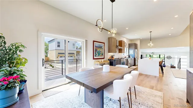 a view of a dining room and livingroom with furniture wooden floor a chandelier