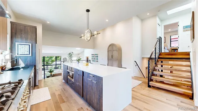 a kitchen with stainless steel appliances kitchen island a large island in the center and wooden floors