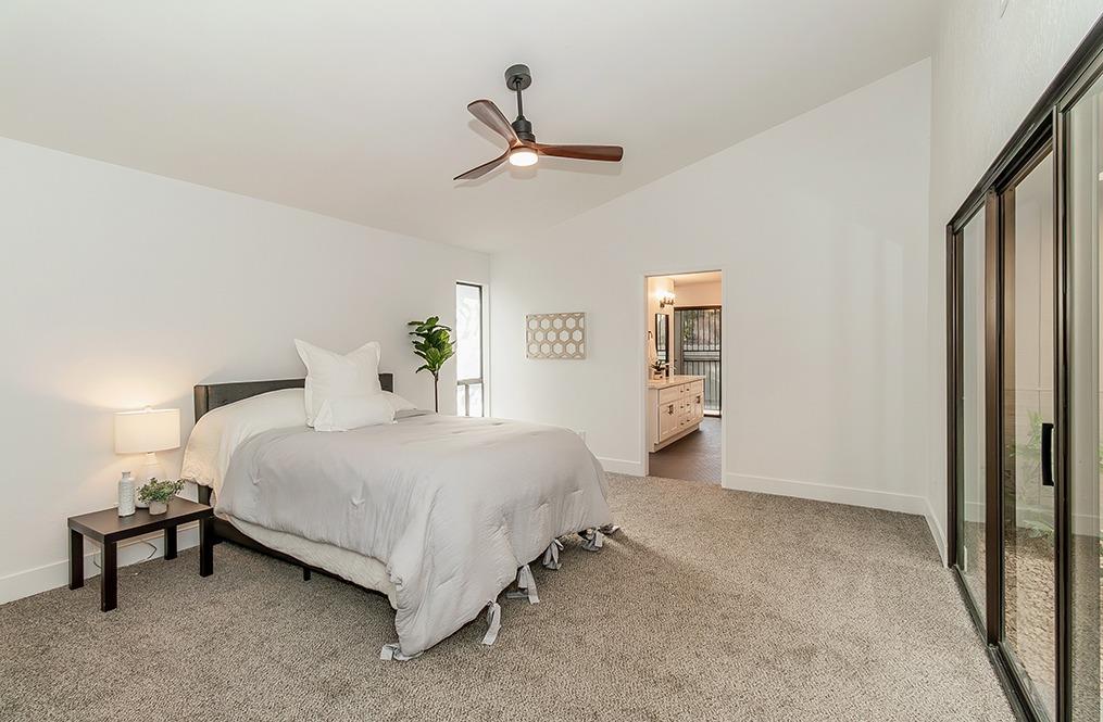 1824 Cougar Lane Clovis, CA 93611 - Photo 16 of 31 a spacious bedroom with a bed and a lamp
