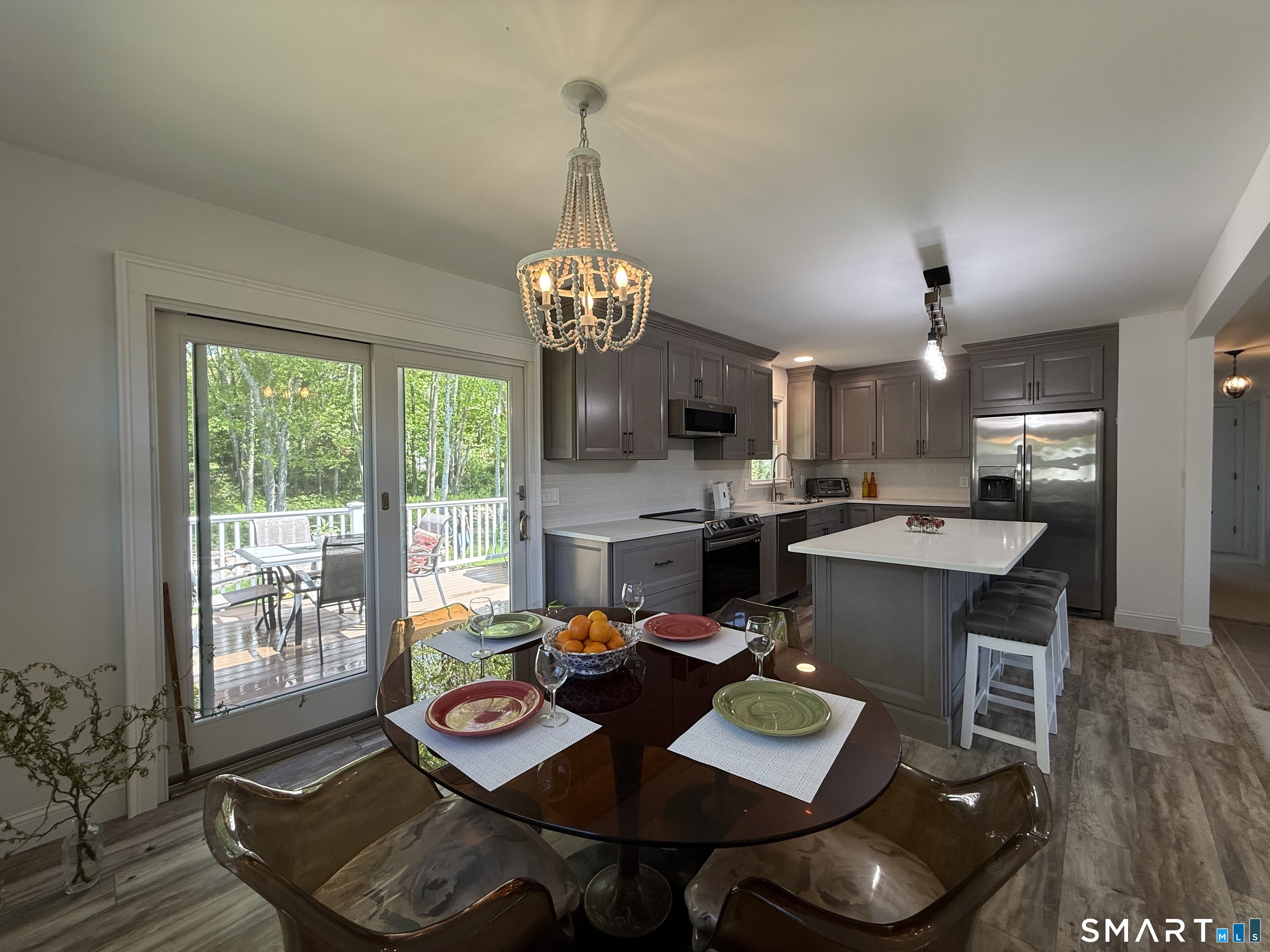 29 Deer Ridge Road Stonington, CT 06378 - Photo 24 of 35 a view of a dining room with furniture a chandelier and wooden floor