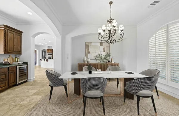 a dining room with furniture a chandelier and wooden floor