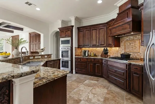 a kitchen with kitchen island granite countertop a sink stove and cabinets