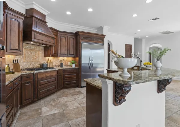 a kitchen with stainless steel appliances granite countertop a sink refrigerator and cabinets