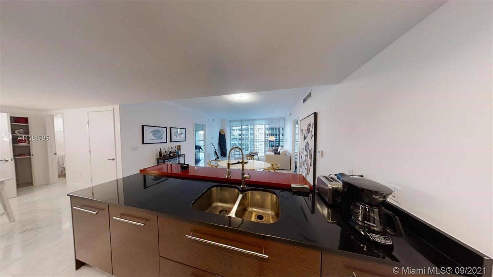 475 Brickell Avenue, Unit 1909 Miami, FL 33131 - Photo 8 of 12 a living room with a couch and a stove with wooden floor