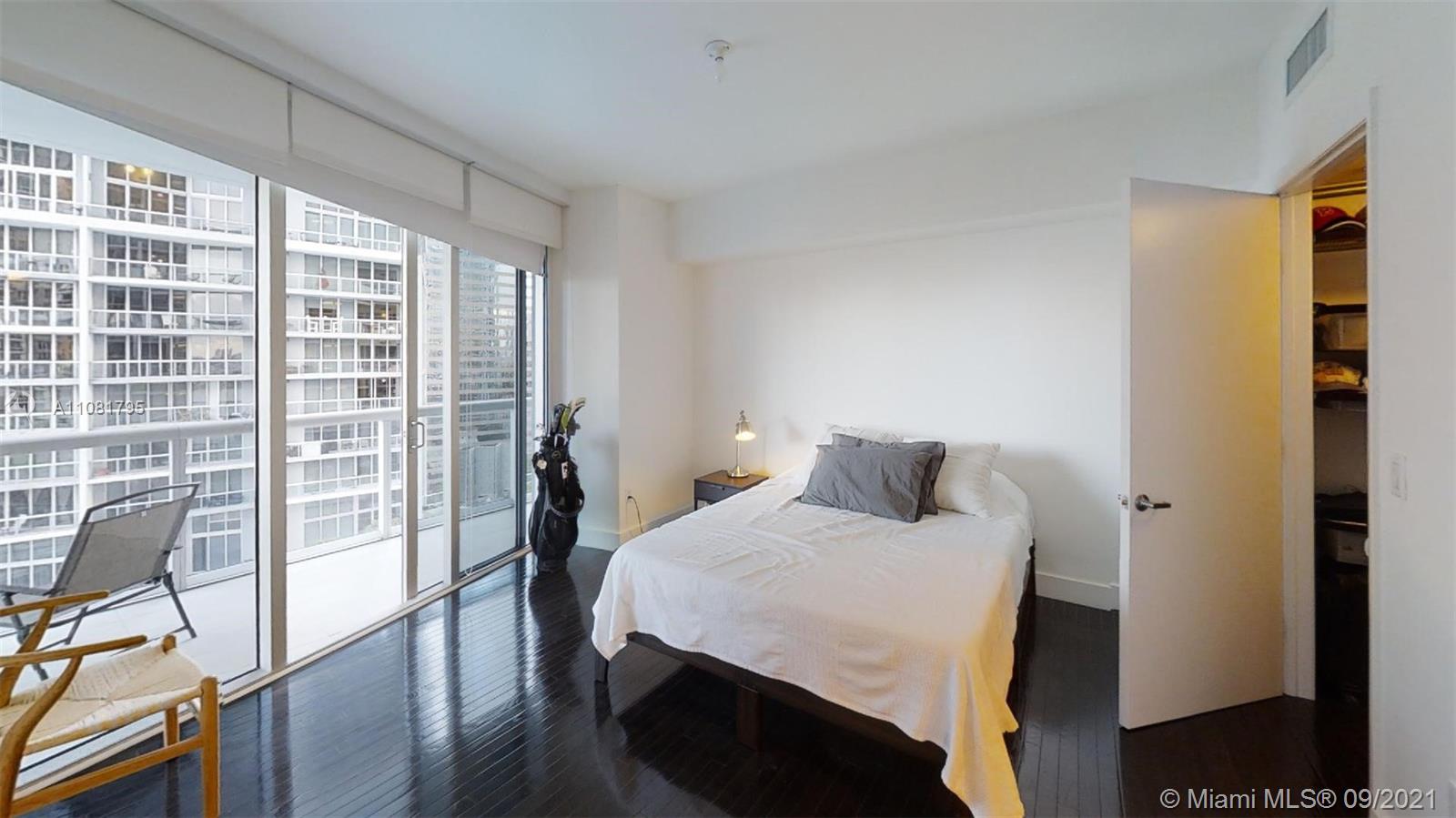 475 Brickell Avenue, Unit 1909 Miami, FL 33131 - Photo 10 of 12 a bedroom with a bed and glass door