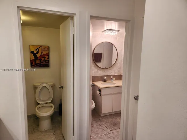 a bathroom with a toilet a sink and mirror