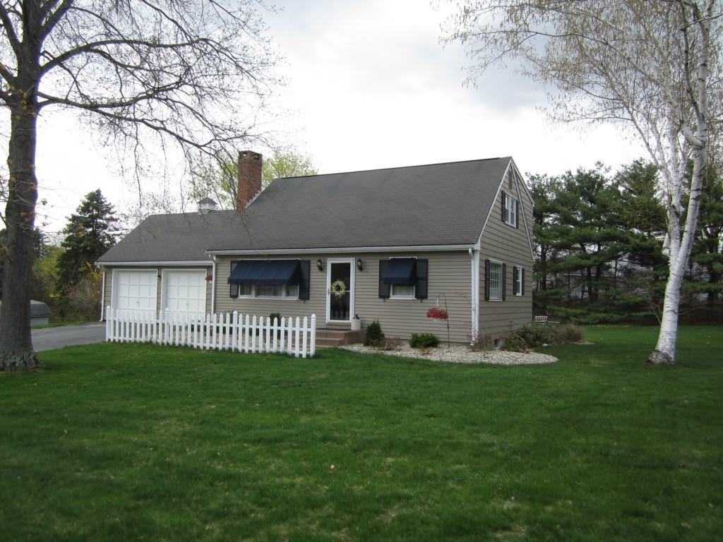 a front view of a house with a garden and trees