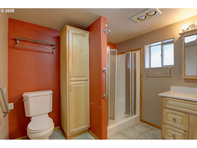 a bathroom with a toilet sink a shower and a window