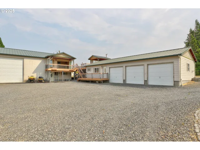 a view of a house with a big yard and large trees