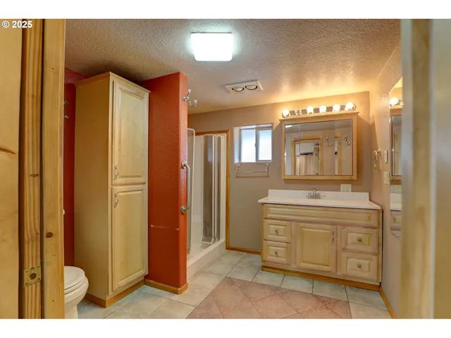 a bathroom with a granite countertop sink a mirror and a shower