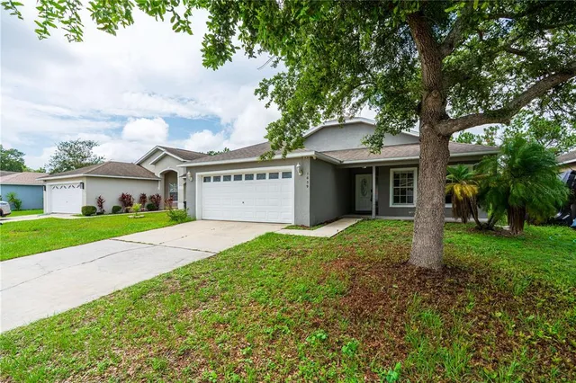a front view of a house with a yard and an trees