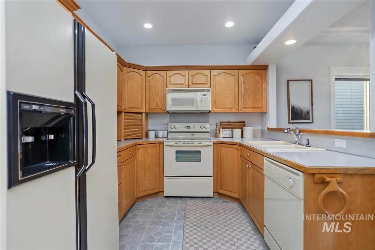 25074 The Driving Lane Caldwell, ID 83607 - Photo 6 of 32 Kitchen featuring white appliances, light countertops, a peninsula, and recessed lighting