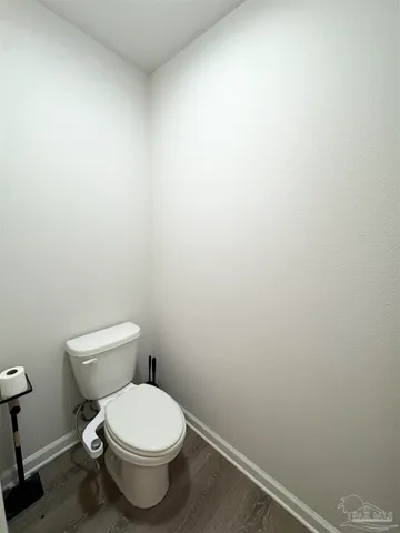a white toilet sitting next to a white wall