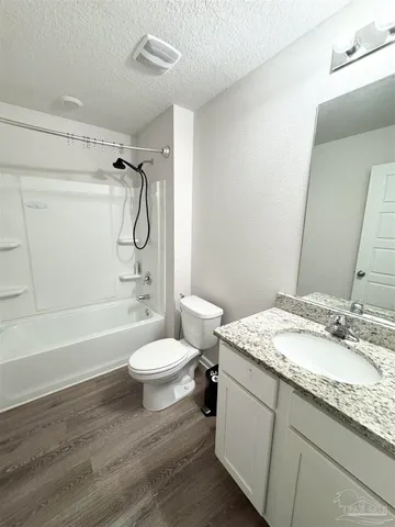 a bathroom with a granite countertop sink toilet and shower