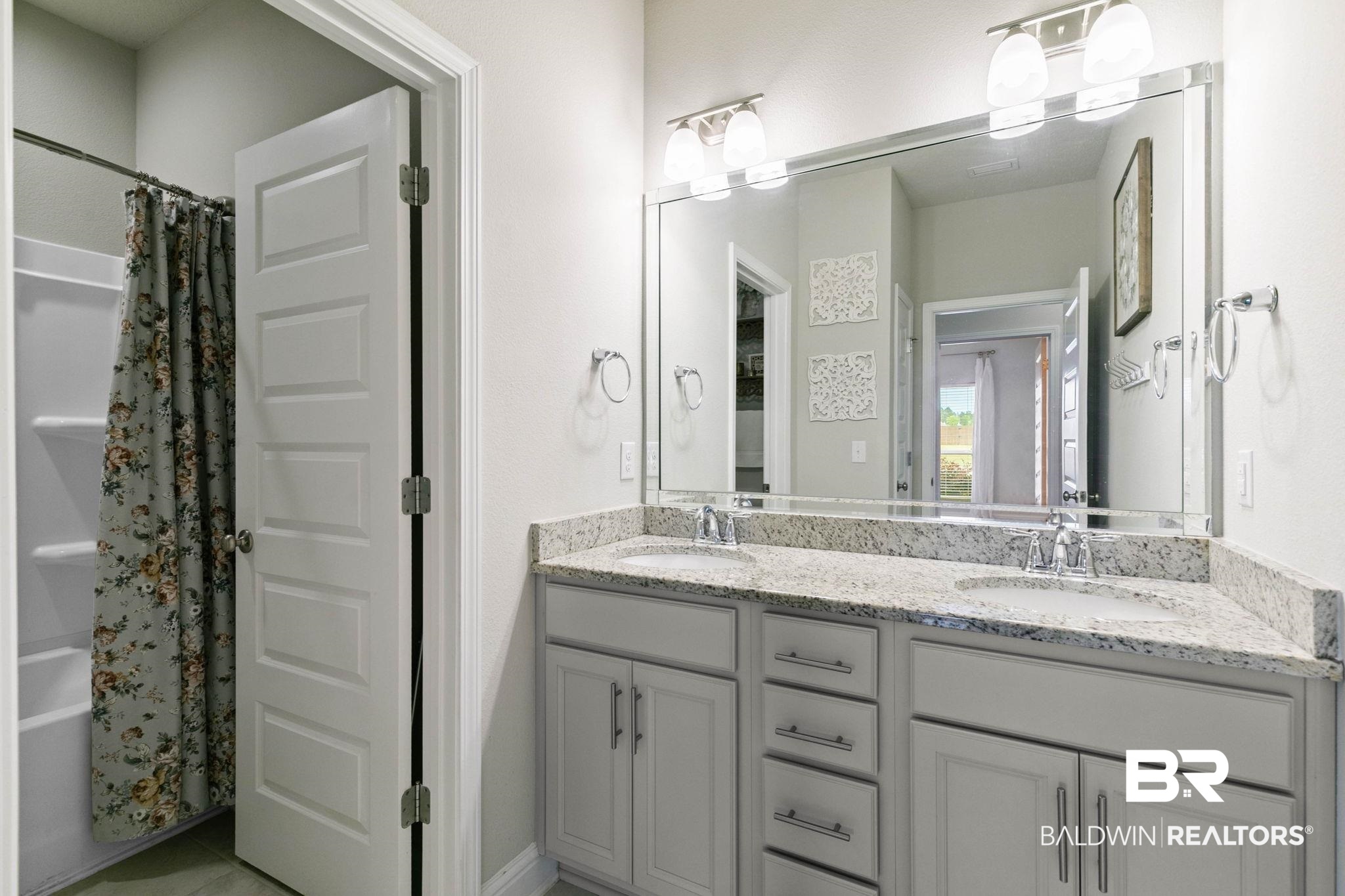 31187 Spoonbill Road Daphne, AL 36527 - Photo 35 of 85 Bathroom featuring a dual vanity with light-toned countertops, undermount sinks, and chrome faucets