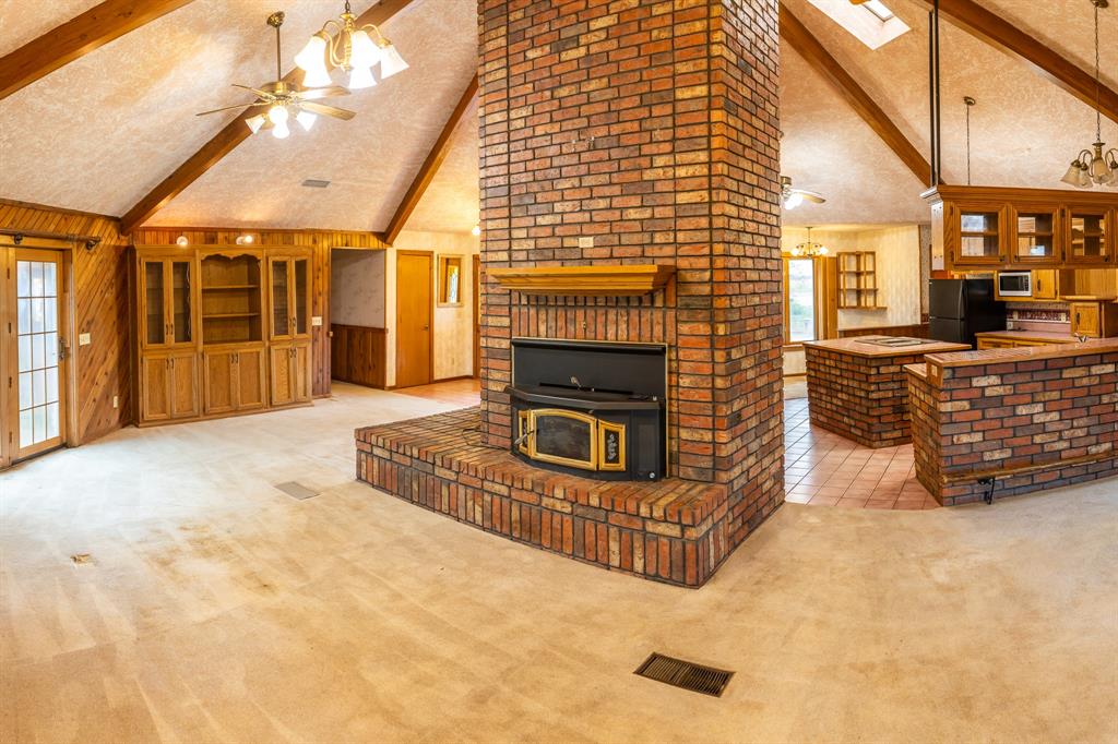 3710 Fm 2407 Rochester, TX 79544 - Photo 1 of 1 Living room featuring beamed ceiling, a fireplace, ceiling fan with notable chandelier, and high vaulted ceiling. What a great layout!