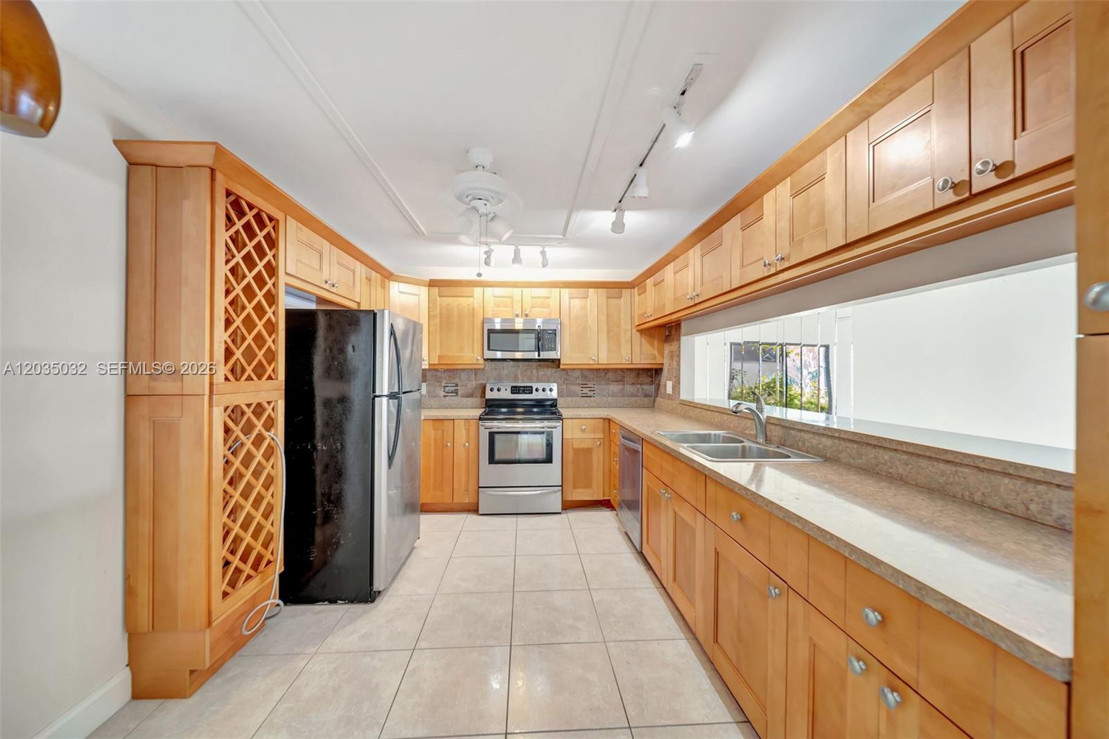 5223 Gate Lake Road, Unit 5223 Tamarac, FL 33319 - Photo 9 of 37 a large kitchen with stainless steel appliances kitchen island granite countertop a refrigerator and a sink