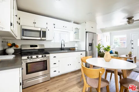 a kitchen with stainless steel appliances a white stove top oven and a refrigerator