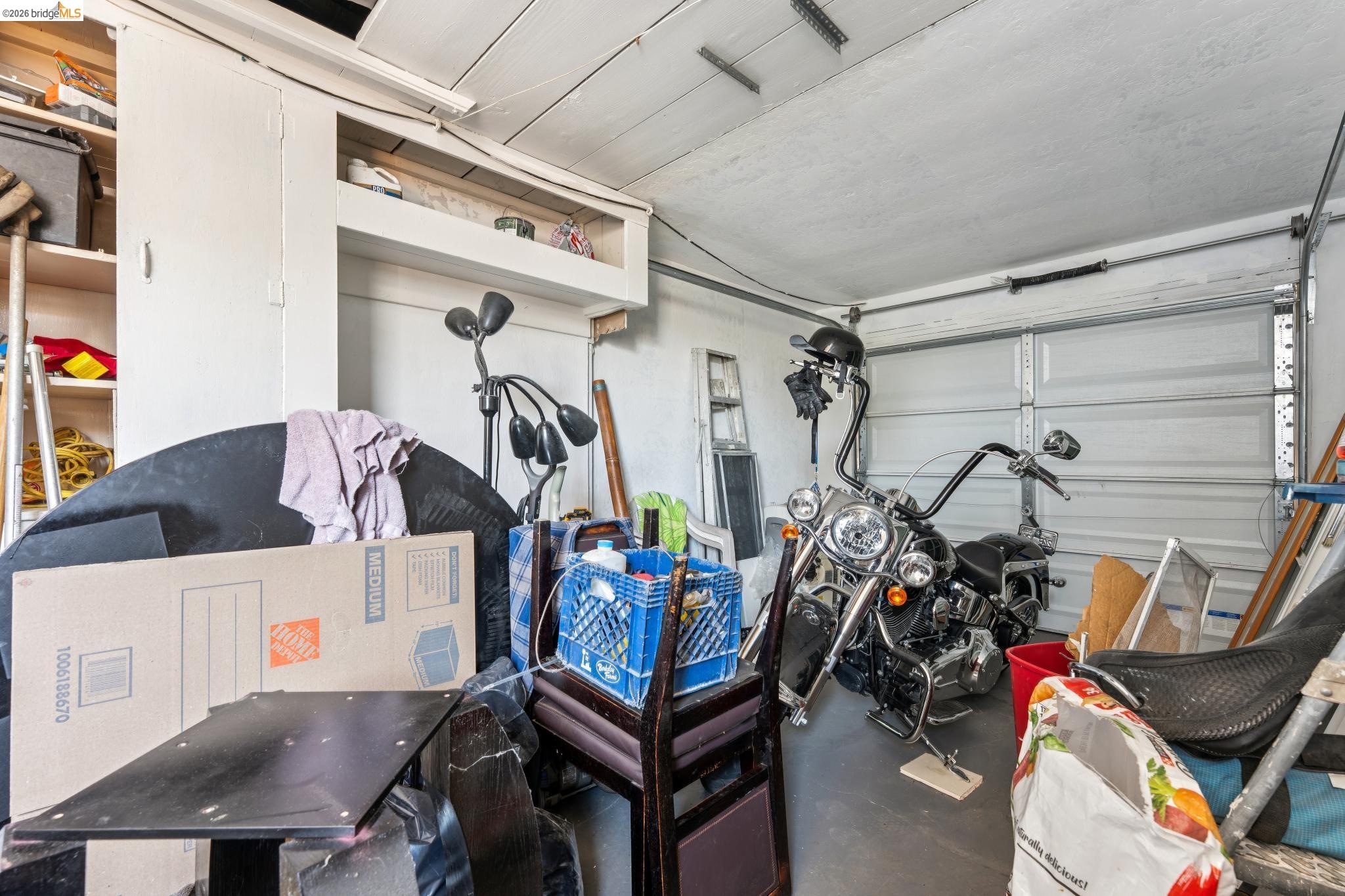 2879 Rheem Avenue Richmond, CA 94804 - Photo 45 of 45 Garage with built-in cabinetry, overhead storage, and white panel garage door