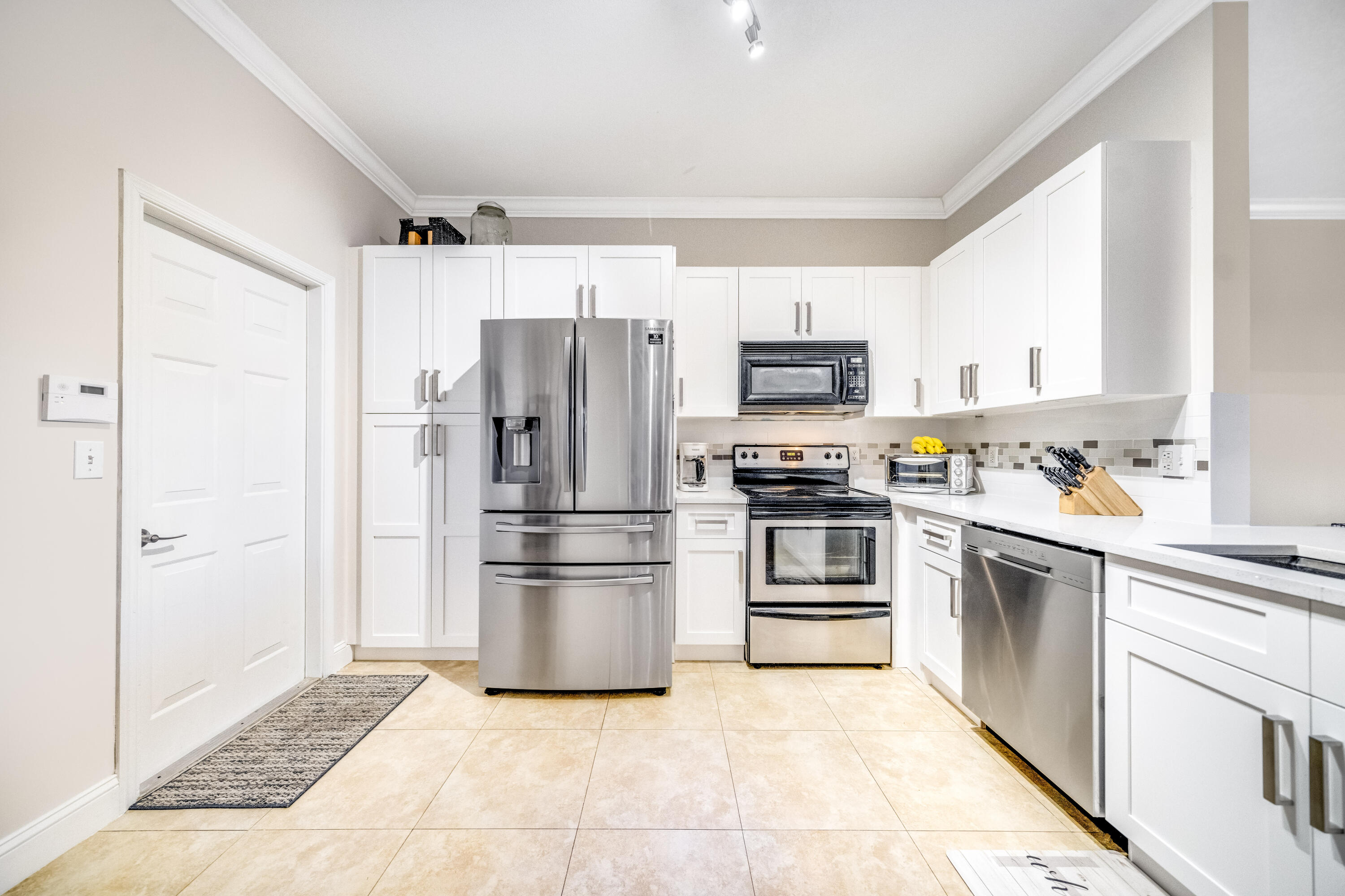5236 Eagle Cay Way Coconut Creek, FL 33073 - Photo 12 of 33 a kitchen with a refrigerator a stove top oven and kitchen island