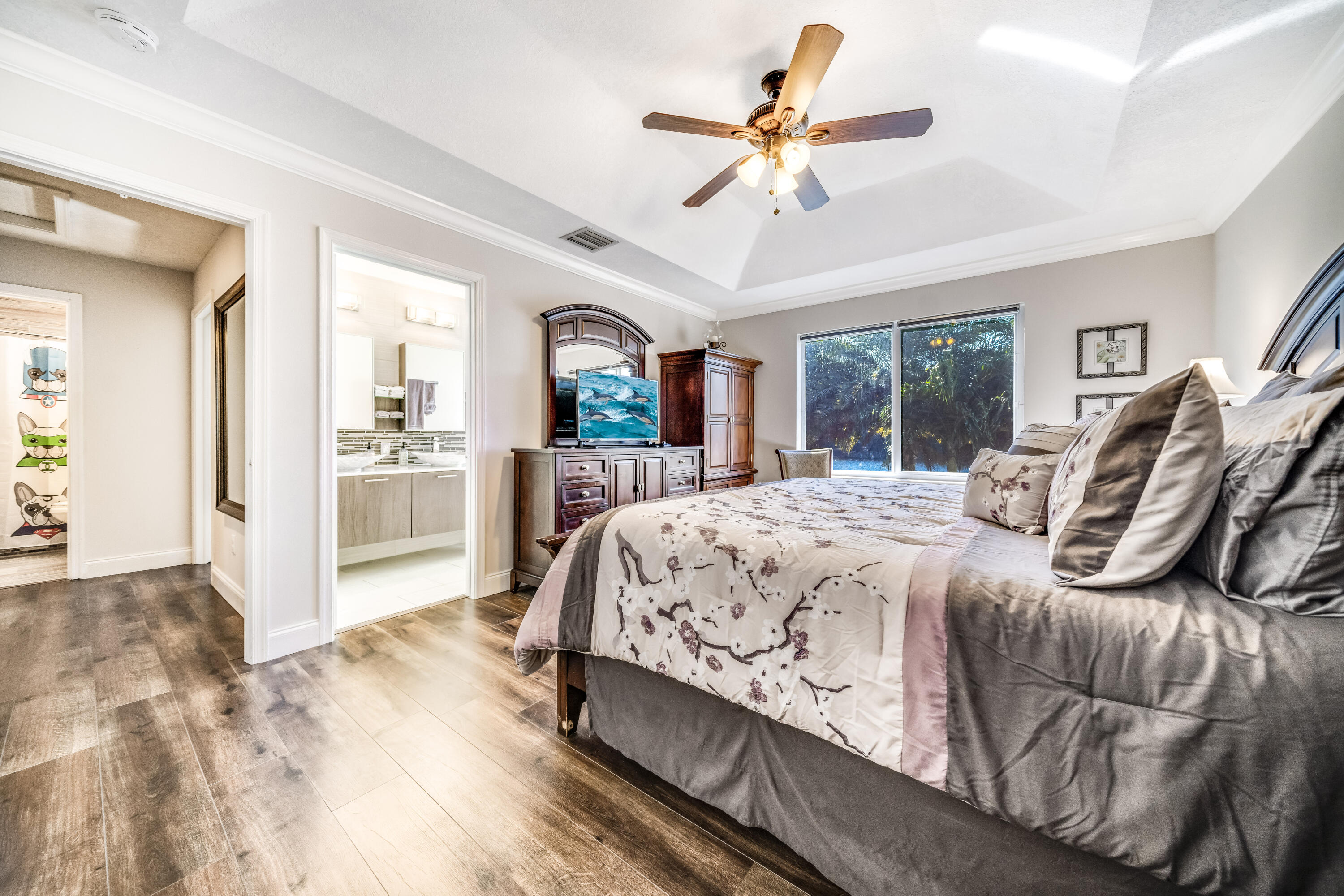 5236 Eagle Cay Way Coconut Creek, FL 33073 - Photo 22 of 33 a spacious bedroom with a large bed a chandelier and windows