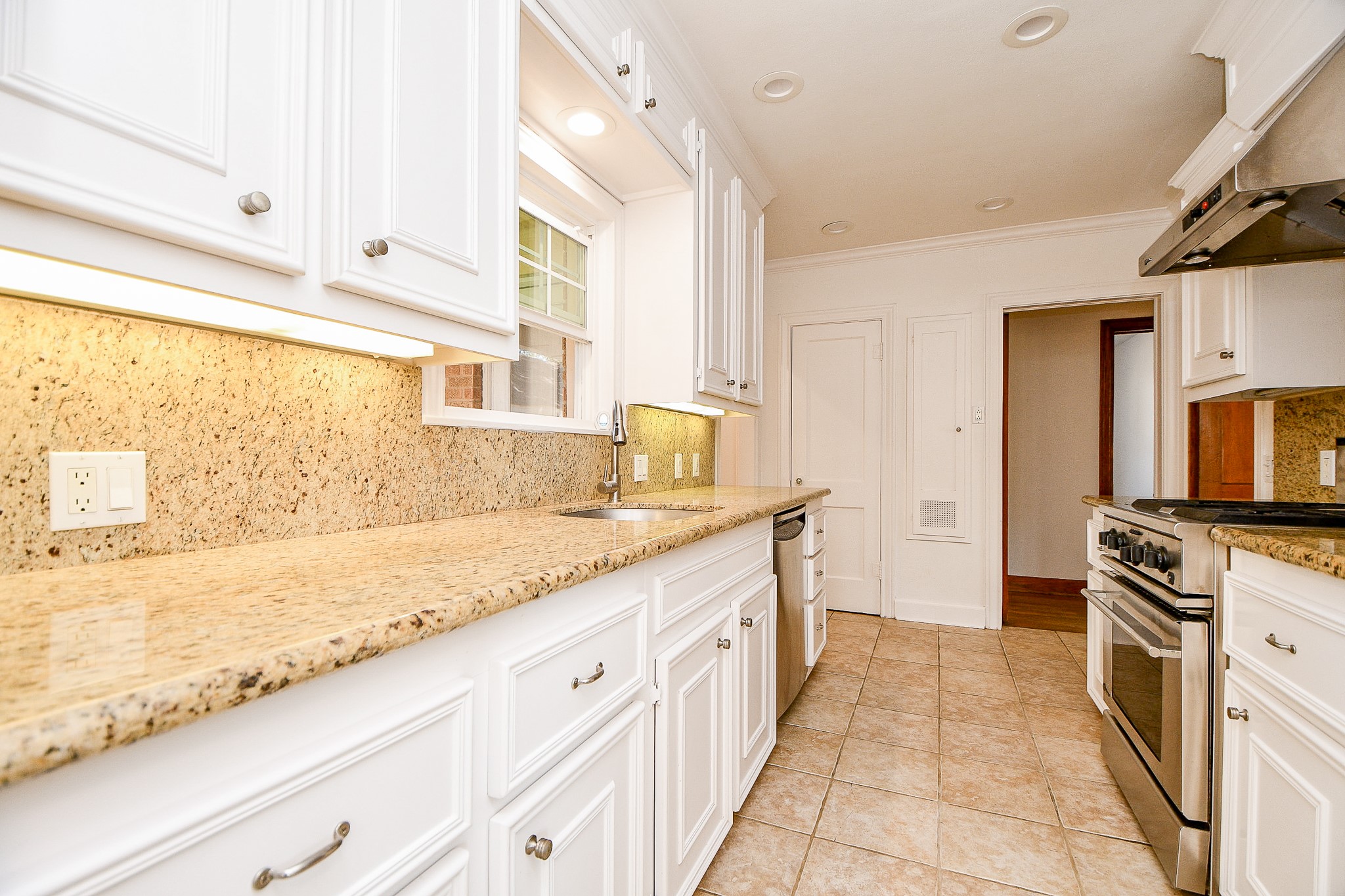 609 Milwaukee Street Houston, TX 77009 - Photo 17 of 32 a kitchen with granite countertop a sink stainless steel appliances a counter top space and cabinets
