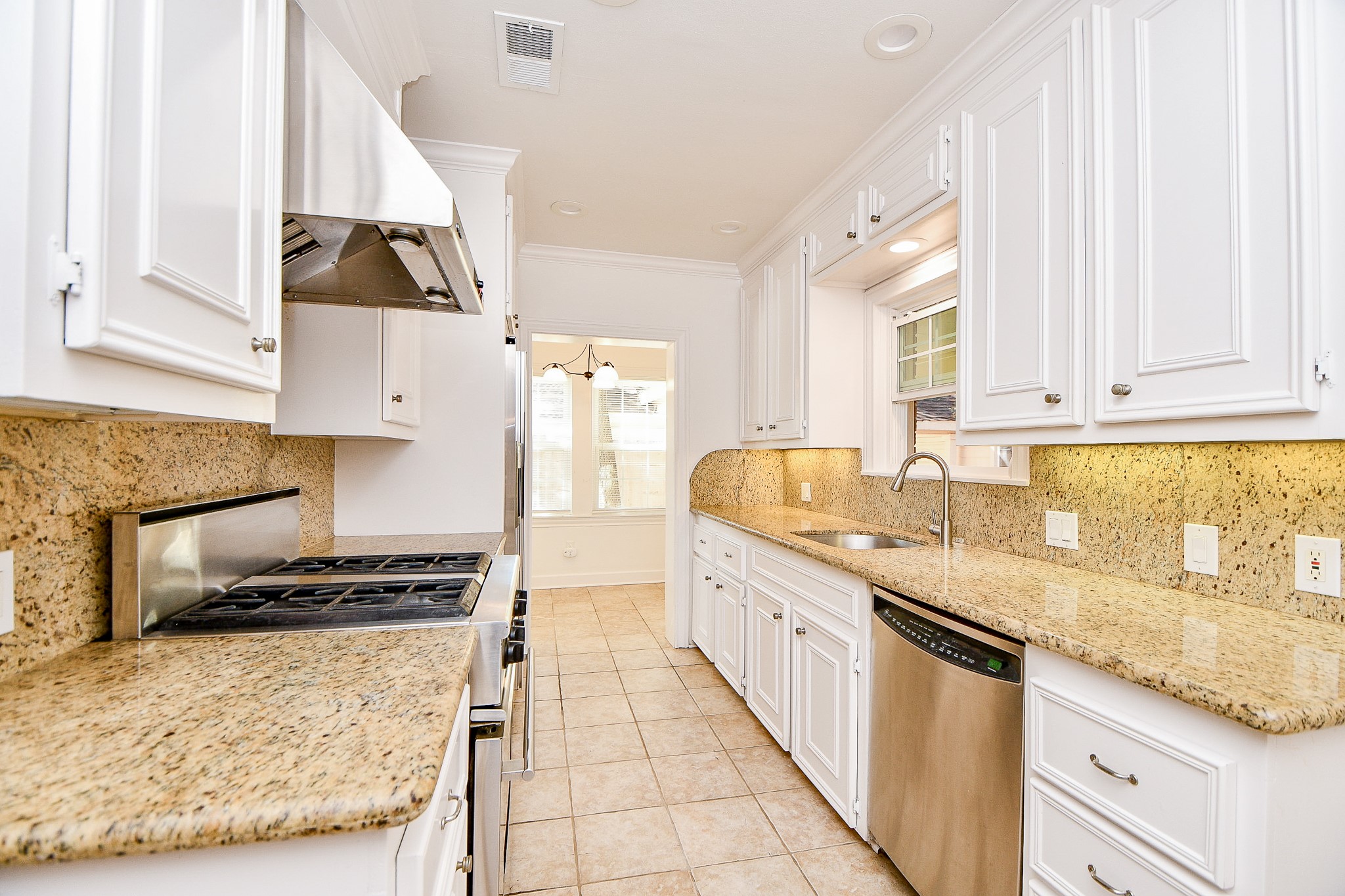 609 Milwaukee Street Houston, TX 77009 - Photo 19 of 32 a kitchen with granite countertop a sink stove and cabinets
