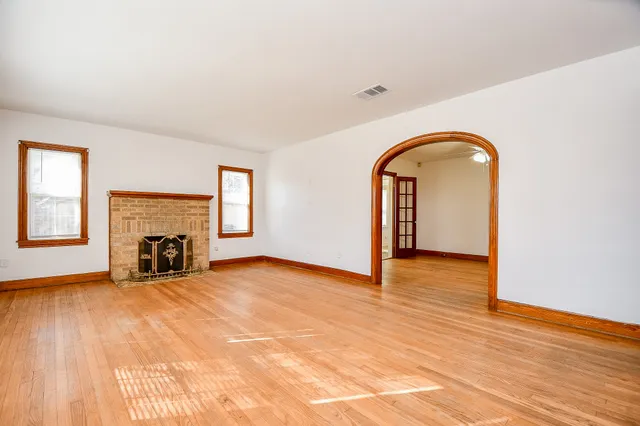 a view of an empty room with window and fireplace