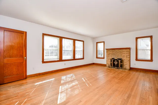 a view of an empty room with window and fire place