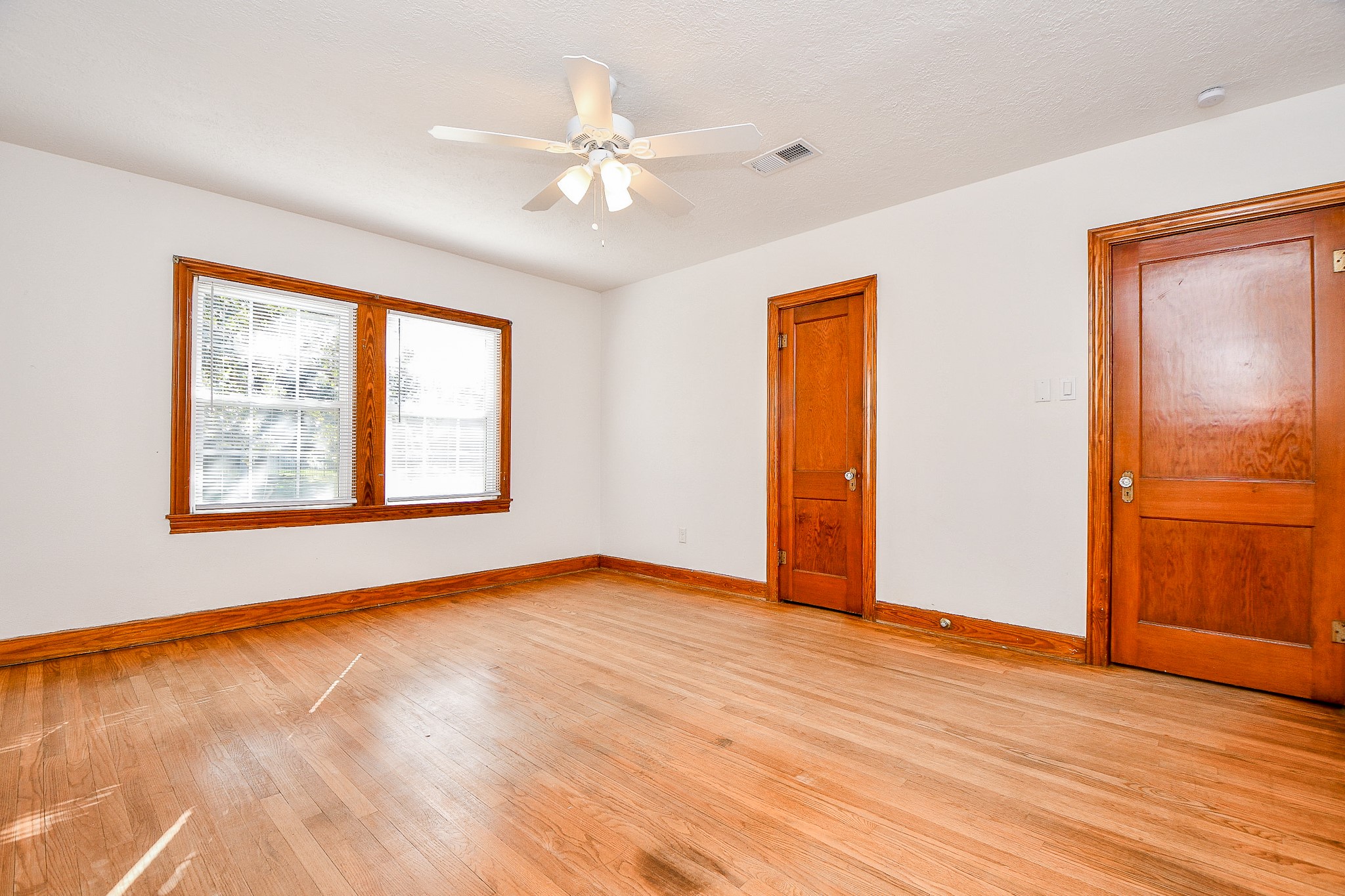 609 Milwaukee Street Houston, TX 77009 - Photo 7 of 32 a view of an empty room with window and wooden floor