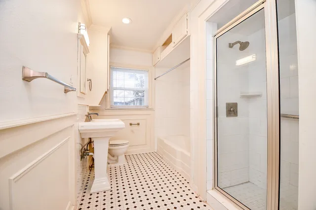 a bathroom with a sink a toilet and shower