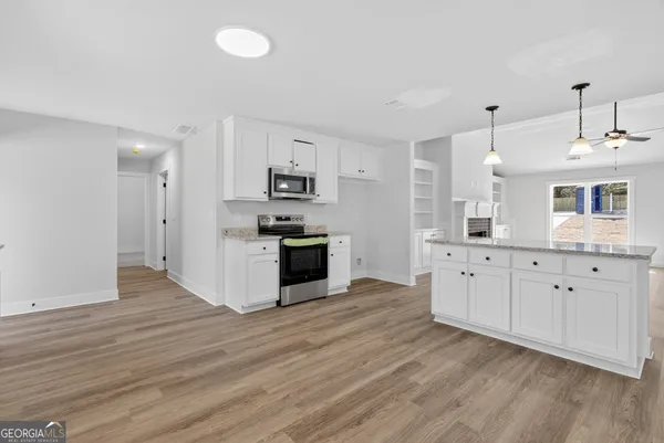 a large kitchen with cabinets wooden floor and a sink