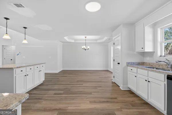 a view of a room with wooden floor chandelier and window