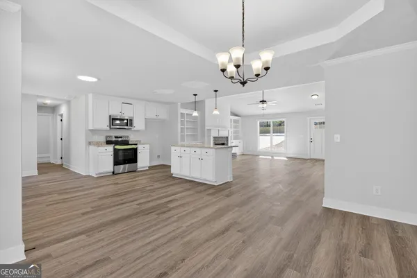 a large kitchen with cabinets wooden floor and stainless steel appliances