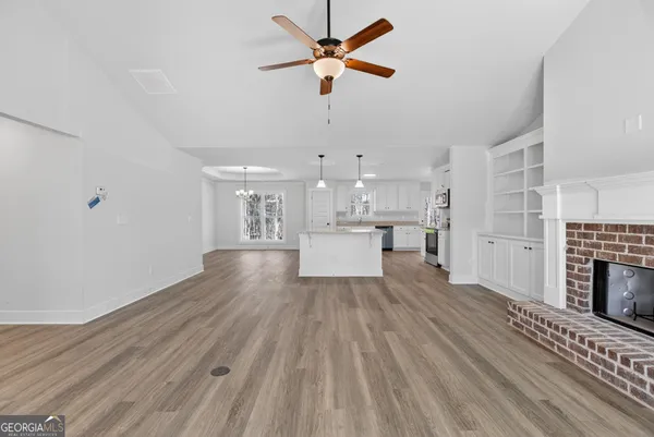 a view of a kitchen with wooden floor a sink and a kitchen view