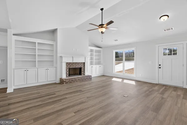 a view of an empty room with a fireplace and a window
