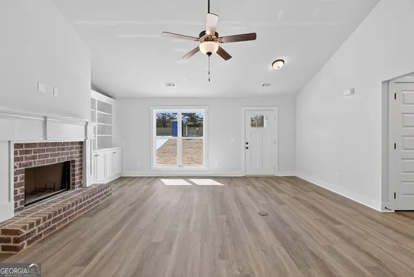 wooden floor fireplace and windows in an empty room