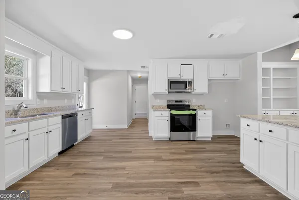 a large kitchen with cabinets wooden floor and stainless steel appliances
