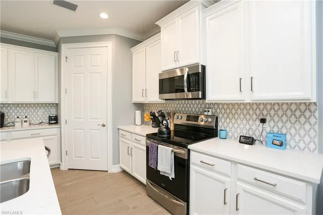 a kitchen with stainless steel appliances a stove microwave and sink