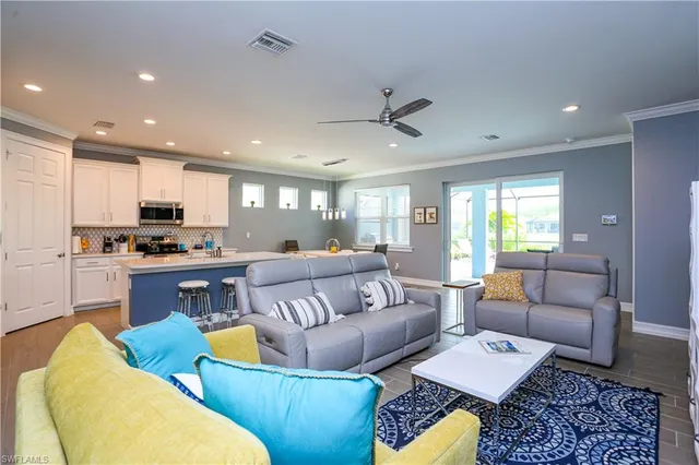 a living room with furniture kitchen and a wooden floor