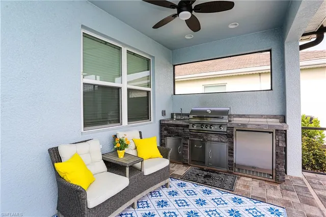 a kitchen with a stove kitchen island wooden floor and a view of living room